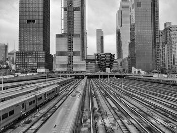 Railroad tracks amidst buildings in hudson yards in new york against sky