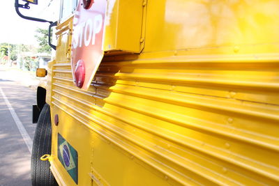 Close-up of yellow car on road