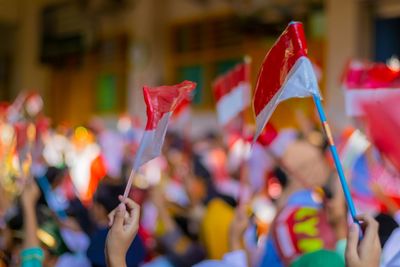 Cropped hand of woman holding flag of indonesia
