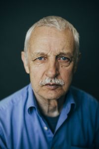 Portrait of mature man against black background