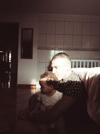 Rear view of mother and daughter at home