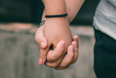 Close-up of people holding hands outdoors