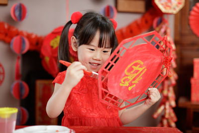 Young chinese girl making traditional chinese  lucky gretting card for celerating chinese new year