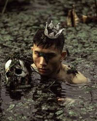 Man wearing crown while swimming in lake