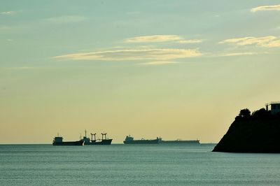 Ship sailing on sea against sky during sunset