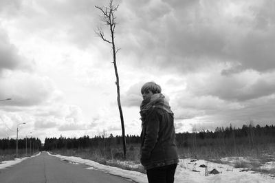 Rear view of woman standing on snow covered land