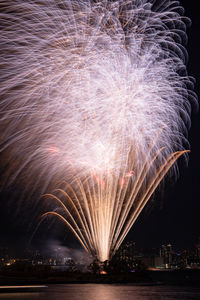 Firework display over river at night