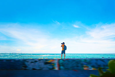 Man photographing while standing against sky