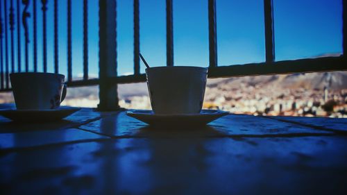 Close-up of table against blue sky seen through window