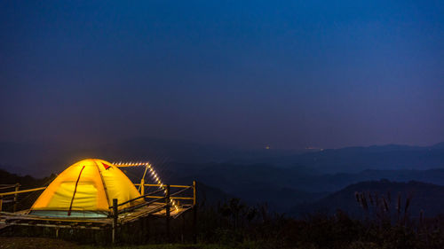 Illuminated tent against sky at night