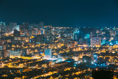 Illuminated cityscape against sky at night