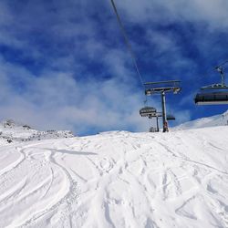 Ski lift over snowcapped mountains in tyrol/austria against sky