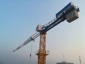 Low angle view of crane against clear sky