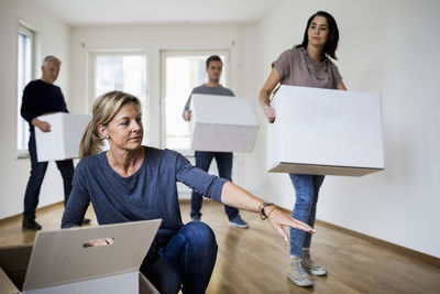 Family of four with cardboard boxes moving into new house