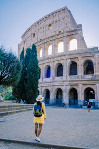 Rear view of woman walking in front of historical building