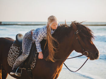 Young woman horseback riding at beach