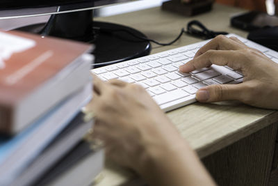 Cropped hands of man using laptop on table