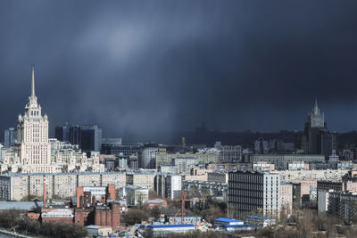Buildings in city against cloudy sky