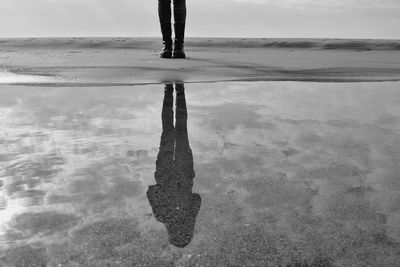 Low section of man standing in puddle