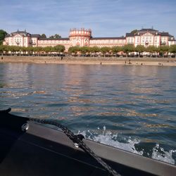 Buildings by river against sky in city