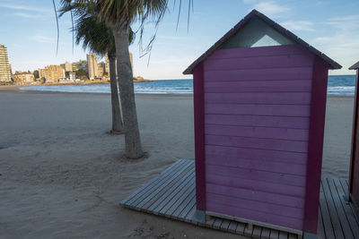 Beach hut by sea against sky