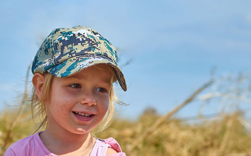 Portrait of young woman wearing hat against sky