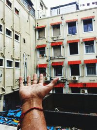 Close-up of hand against building