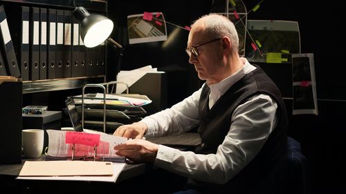 Side view of man working at table