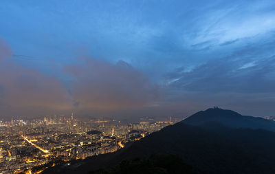 Aerial view of city against cloudy sky