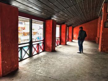 Rear view of man walking in corridor of building