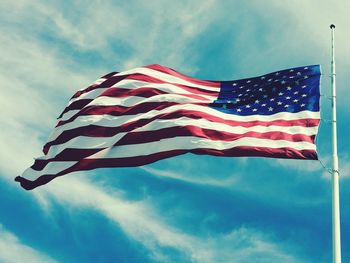 Low angle view of american flag against blue sky