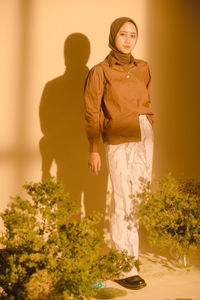 Rear view of woman standing against wall