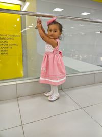 Side view portrait of cute girl standing on tiled floor