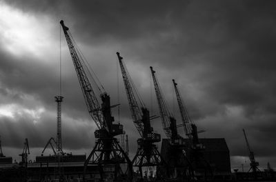 Low angle view of cranes against sky