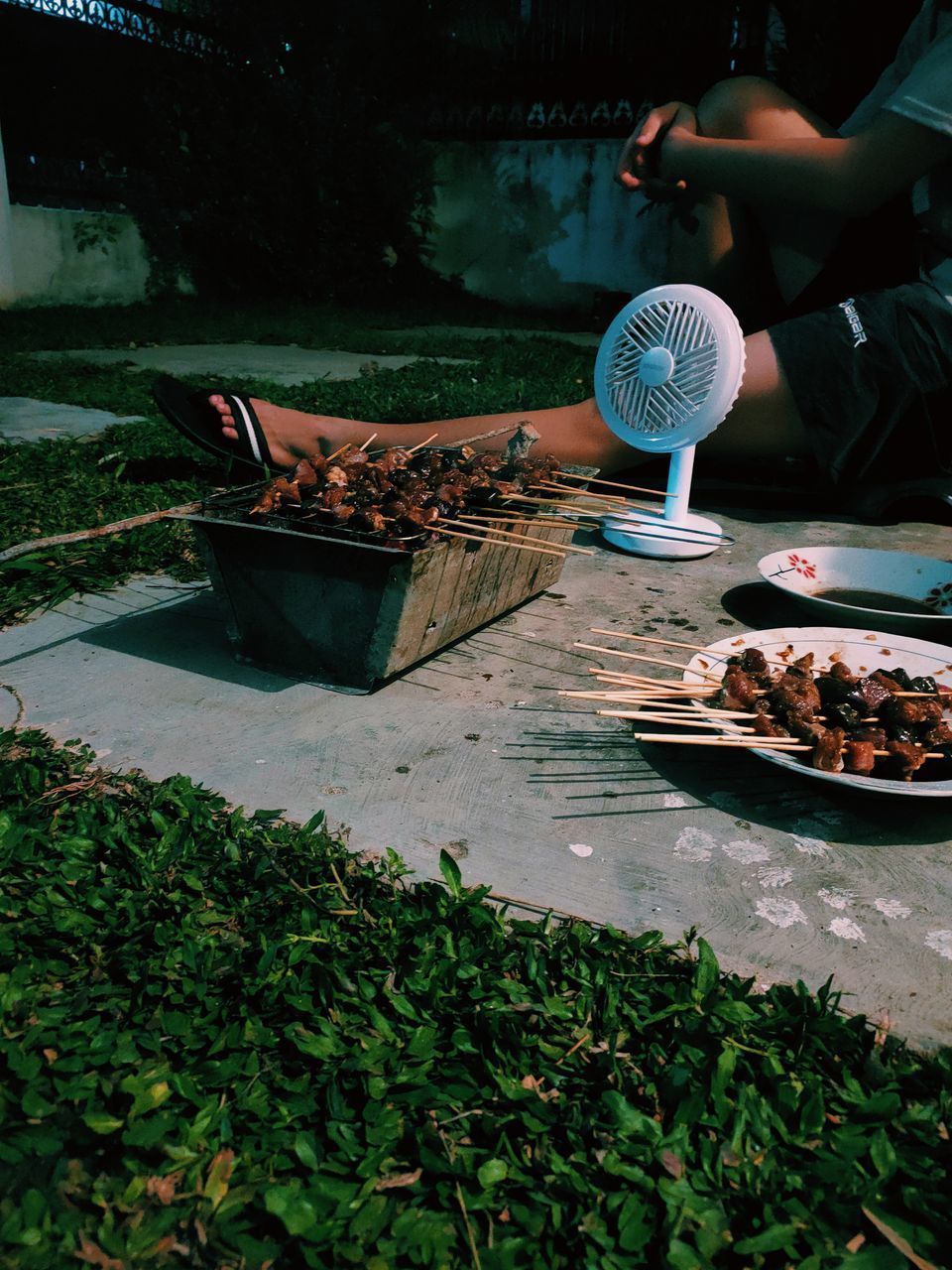 MAN PREPARING FOOD IN BACKYARD