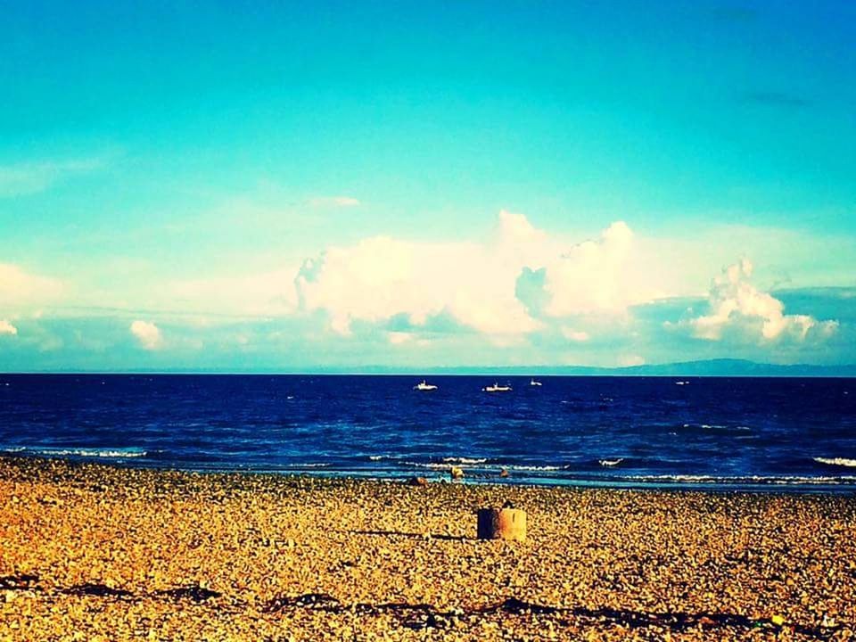 VIEW OF CALM BEACH AGAINST THE SKY