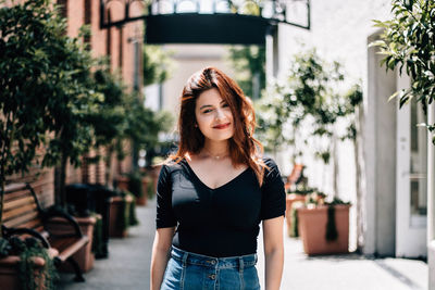 Portrait of beautiful young woman standing outdoors