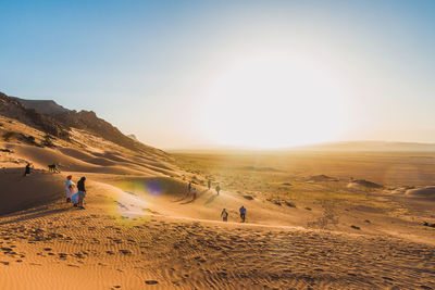 People on desert against sky