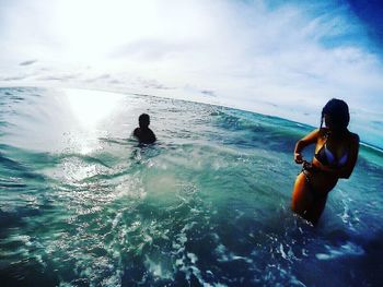 Man swimming in sea against sky