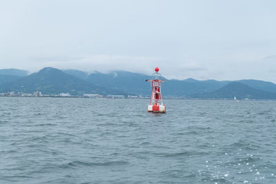 Lighthouse by sea against sky