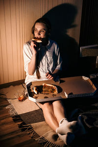 Loneliness in christmas holidays, valentines day. young alone woman in pajamas eating pizza near
