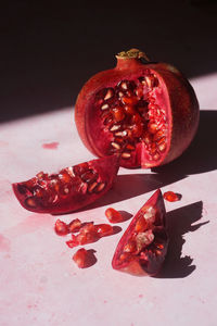 Close up of slices of pomegranate on pink background