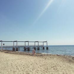 Man on beach against clear sky