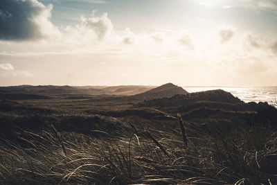 Scenic view of land and sea against sky