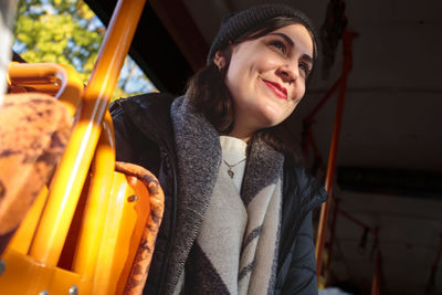 Portrait of smiling young woman standing in train