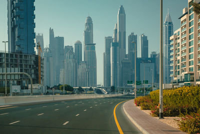 Road by buildings in city against sky. united arab emirates. dubai city view highway.