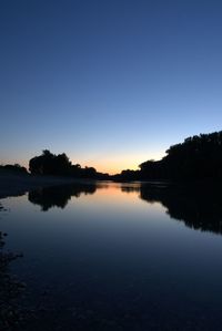 Scenic view of lake against clear sky during sunset