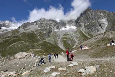People on mountains against sky