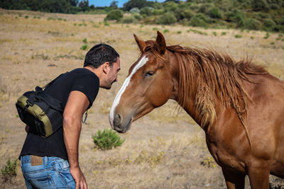 Man looking at horse