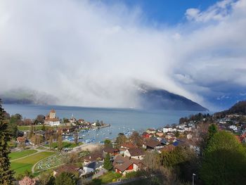 High angle view of townscape by sea against sky